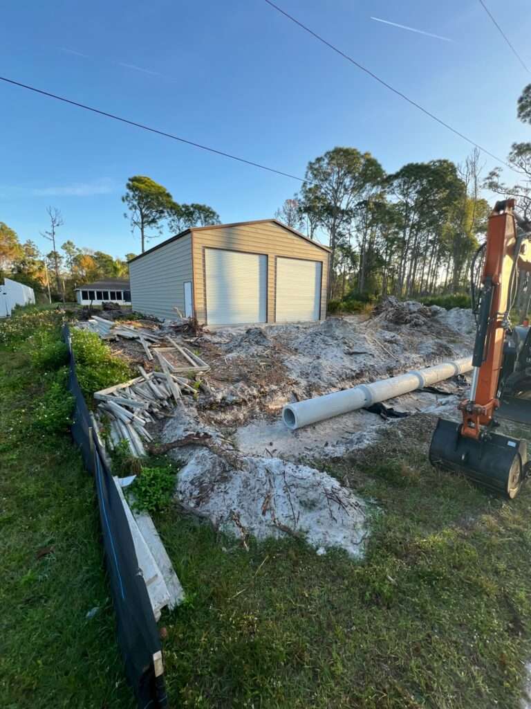 Orange excavator digging a trench for a french drain.