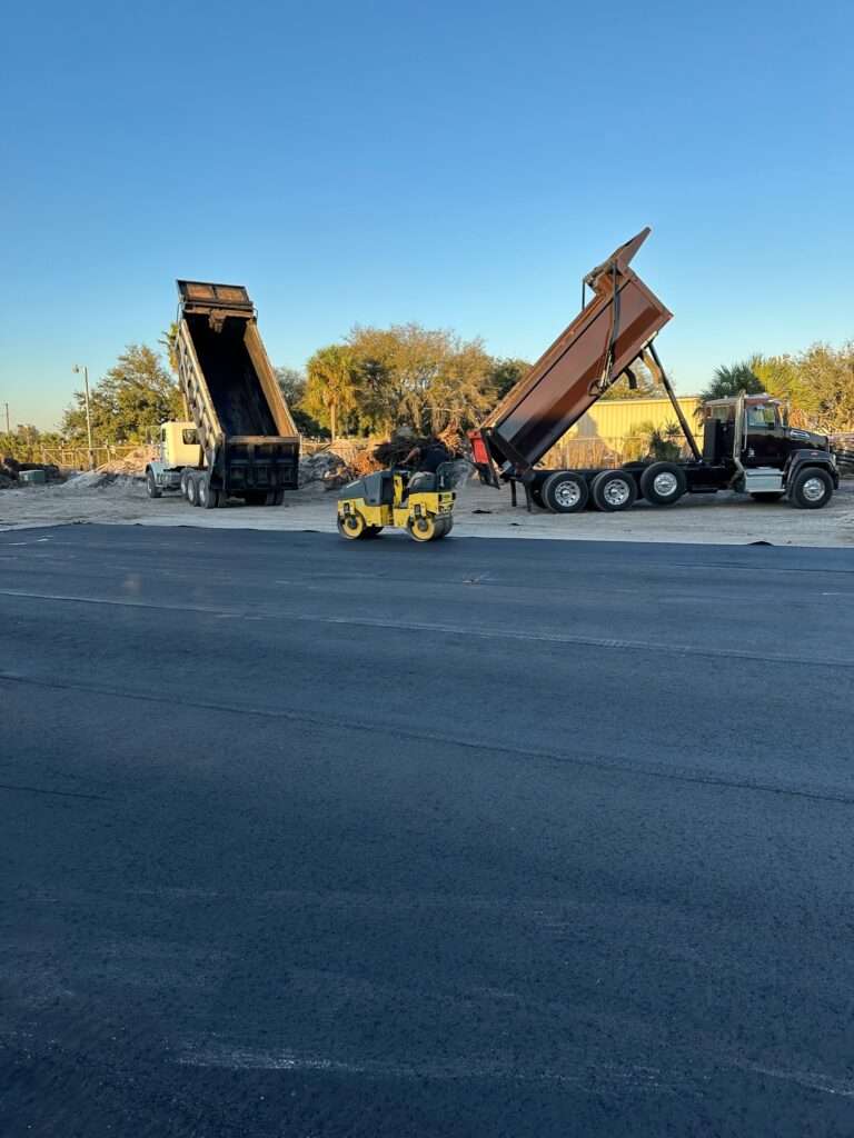 Asphalt paving equipment; dump trucks and road roller.